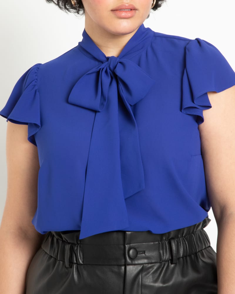 Front of a model wearing a size 14 Willow Flutter Sleeve Blouse in Bright Cobalt by ELOQUII. | dia_product_style_image_id:196127